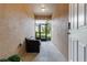 Neutral hallway features a bench, textured walls, and a view to the outside through a glass-paneled exterior door at 11916 Castine St, New Port Richey, FL 34654