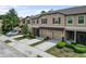 Street view of townhomes with manicured lawns, garages, and neutral exteriors on a sunny day at 11916 Castine St, New Port Richey, FL 34654
