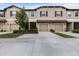 Inviting townhomes showcasing attached garages, landscaped yards, and neutral stucco exteriors under a cloudy sky at 11916 Castine St, New Port Richey, FL 34654