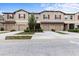 Street view of townhomes with attached garages and tan exteriors showcasing inviting curb appeal with a blue sky at 11916 Castine St, New Port Richey, FL 34654
