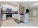 Well-lit kitchen featuring stainless steel appliances, white cabinetry, granite countertops, and an adjacent living area at 11916 Castine St, New Port Richey, FL 34654