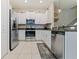 Bright kitchen with stainless steel appliances, sleek white cabinets, granite counters, and tile floors at 11916 Castine St, New Port Richey, FL 34654