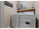 Efficient laundry area equipped with a washer, dryer, and practical storage solutions at 11916 Castine St, New Port Richey, FL 34654