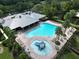Aerial view of a community pool featuring a splash pad, lounge chairs, and lush landscaping, perfect for relaxing and enjoying the Florida sun at 11916 Castine St, New Port Richey, FL 34654