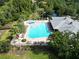 Overhead shot of a community pool area, showcasing the expansive pool, splash pad, playground, and beautiful green spaces at 11916 Castine St, New Port Richey, FL 34654