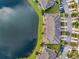 Overhead aerial view of townhome community on lake, manicured lawns and trees at 12025 Greengate Dr, Hudson, FL 34669
