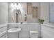 Stylish half bathroom with updated lighting, framed oval mirror, and a decorative wall panel at 12025 Greengate Dr, Hudson, FL 34669