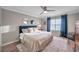 Primary bedroom featuring a plush bed, two mirrors, and elegant blue curtains at 12025 Greengate Dr, Hudson, FL 34669