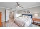 Bright bedroom with a plush bed, natural light, ceiling fan, and hardwood floors at 12025 Greengate Dr, Hudson, FL 34669