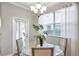 Dining area with contemporary glass table, modern lighting, and natural light from the sliding doors at 12025 Greengate Dr, Hudson, FL 34669