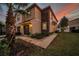 Two-story home featuring a stucco exterior, stone accents, attached garage, and landscaped yard at 12025 Greengate Dr, Hudson, FL 34669