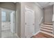Hallway with neutral walls and white trim leads to a bathroom and features stairs with wood treads at 12025 Greengate Dr, Hudson, FL 34669