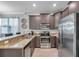 Modern kitchen featuring stainless steel appliances, granite countertops, and dark brown cabinetry at 12025 Greengate Dr, Hudson, FL 34669