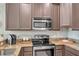 Updated kitchen with granite countertops, stainless steel appliances, and modern mocha cabinetry at 12025 Greengate Dr, Hudson, FL 34669