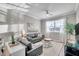 Bright living room with two couches, large windows, stylish decor, and modern ceiling fan at 12025 Greengate Dr, Hudson, FL 34669