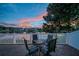 Outdoor patio with table and chairs offers serene lake views at sunset at 12025 Greengate Dr, Hudson, FL 34669