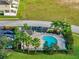 Aerial view of community pool featuring palm trees, lounge chairs, and nearby parking at 12025 Greengate Dr, Hudson, FL 34669