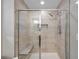 Luxurious walk-in shower with glass doors, a built-in bench, and tile surround at 12025 Greengate Dr, Hudson, FL 34669