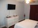 Bright bedroom features a white dresser, flat-screen TV, and cozy decor at 12411 Brookside St, Spring Hill, FL 34609