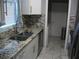 Bright kitchen with granite countertops, stainless steel appliances, and mosaic tile backsplash at 12411 Brookside St, Spring Hill, FL 34609