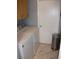 Practical laundry room with white washer and dryer, storage cabinet, and tiled floor at 12411 Brookside St, Spring Hill, FL 34609