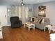 Cozy living room features a modern ceiling fan, neutral walls, and sleek laminate wood flooring at 12411 Brookside St, Spring Hill, FL 34609