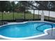 Screened-in pool area with a bright blue pool and a seating area in the backyard at 12411 Brookside St, Spring Hill, FL 34609