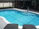Inviting screened-in pool with lounge chairs for relaxing and sunbathing at 12411 Brookside St, Spring Hill, FL 34609