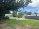Large backyard features a concrete pad, chain link fence, mature shade trees, and an open grassy area at 1309 29Th S St, St Petersburg, FL 33712