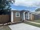 Well-maintained home features a small front yard with mature trees, a driveway and neutral exterior paint at 1309 29Th S St, St Petersburg, FL 33712