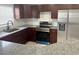 Updated kitchen with dark cabinetry, granite counters, stainless steel appliances, and modern fixtures at 1309 29Th S St, St Petersburg, FL 33712