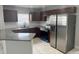 Modern kitchen featuring stainless steel appliances, dark wood cabinetry, granite countertops, and a stylish backsplash at 1309 29Th S St, St Petersburg, FL 33712