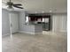 Open-concept living room next to kitchen featuring a ceiling fan, tile flooring, and ample natural light at 1309 29Th S St, St Petersburg, FL 33712