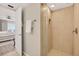 Modern bathroom featuring a glass door shower and access to the main bedroom at 14300 Gulf Blvd # 104, Madeira Beach, FL 33708