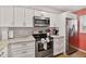 Cozy kitchen featuring stainless steel appliances and white cabinets at 14300 Gulf Blvd # 104, Madeira Beach, FL 33708