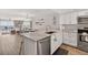 Open kitchen with stainless steel appliances, marble countertops, and living area in the background at 14300 Gulf Blvd # 104, Madeira Beach, FL 33708