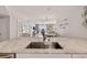 Kitchen sink with stainless steel appliances and living area view at 14300 Gulf Blvd # 104, Madeira Beach, FL 33708