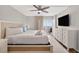 Main bedroom with ceiling fan, flat-screen TV, and balcony access at 14300 Gulf Blvd # 104, Madeira Beach, FL 33708
