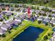 Aerial view of the single Gathering home showcasing the pool, surrounding neighborhood and the large pond at 1601 Fox Grape Loop, Lutz, FL 33558
