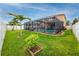 The backyard features a screened-in pool and a well-maintained lawn with mature landscaping at 1601 Fox Grape Loop, Lutz, FL 33558
