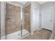 A modern bathroom with a glass-enclosed shower with tiled walls and neutral tile flooring at 1601 Fox Grape Loop, Lutz, FL 33558