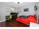 Bedroom with two desks, tv, bed, and hardwood flooring at 1601 Fox Grape Loop, Lutz, FL 33558