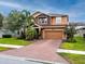 Charming two-story home featuring a brick driveway, two-car garage, and a well-manicured lawn at 1601 Fox Grape Loop, Lutz, FL 33558