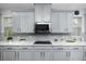 Modern kitchen features gray cabinetry, quartz countertops, and subway tile backsplash at 1601 Fox Grape Loop, Lutz, FL 33558
