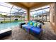 Patio featuring a seating area with plush cushions adjacent to a pool and screened enclosure at 1601 Fox Grape Loop, Lutz, FL 33558
