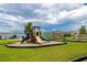 Community playground with slides and picnic tables near the lake with residential homes in the background at 1601 Fox Grape Loop, Lutz, FL 33558