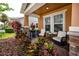 Cozy front porch with stone pillars and colorful plants creating a welcoming outdoor space at 1601 Fox Grape Loop, Lutz, FL 33558
