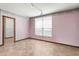 Bright bedroom featuring neutral tile floors, pink walls, window with blinds, and a walk-in closet at 1701 N Tampania Ave, Tampa, FL 33607