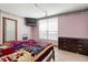 Cozy bedroom with a large window, wood dresser and mounted television for easy viewing at 1701 N Tampania Ave, Tampa, FL 33607