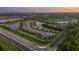 Beautiful aerial view of a community with lakefront properties and lush green surroundings under a colorful sky at 20828 Cattail Blvd, Venice, FL 34292